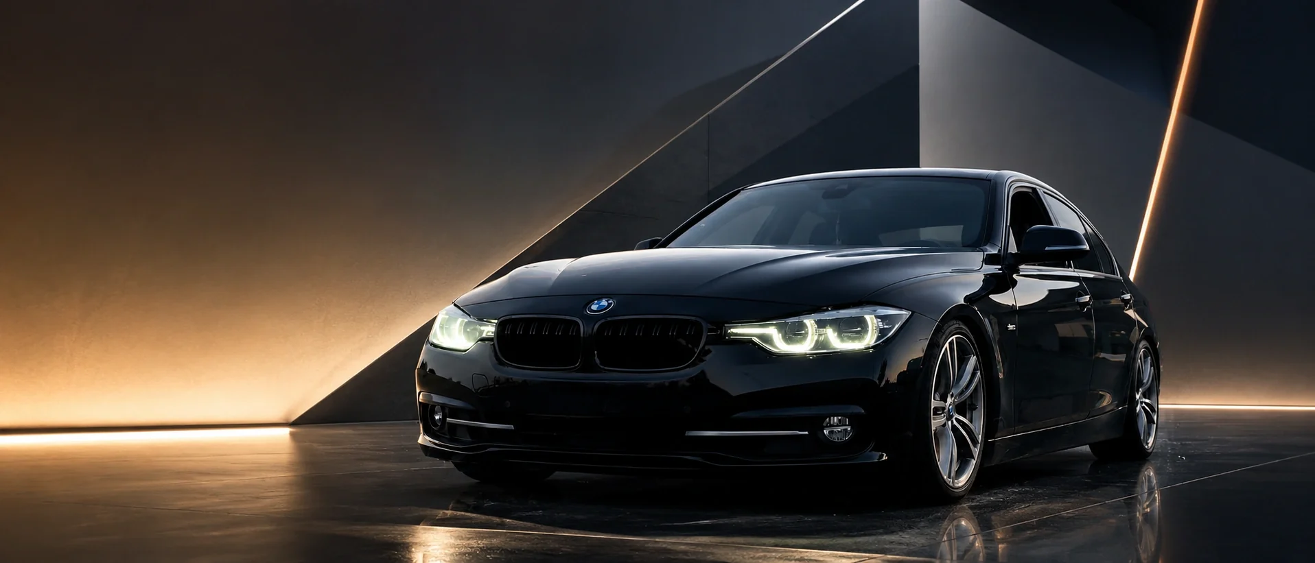 Schwarzer BMW vor einer dunklen Architektur mit warmen Lichtlinien